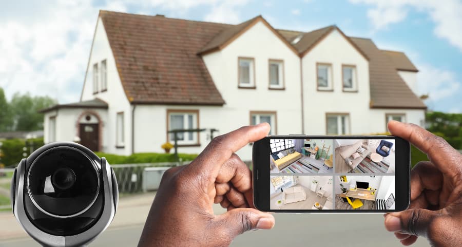 Man holding phone and looking at footage from surveillance cameras